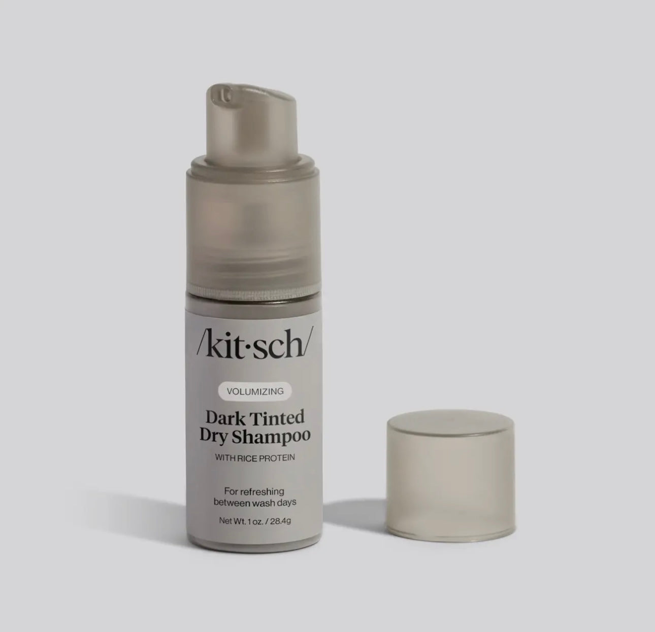 A kit-sch dark tinted dry shampoo bottle on a light gray background