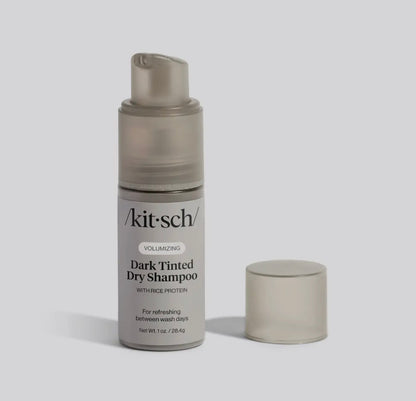A kit-sch dark tinted dry shampoo bottle on a light gray background